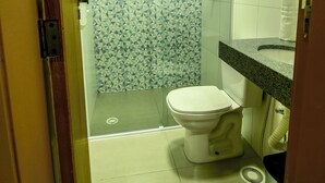 A small bathroom with a toilet, a shower, and a sink. - MLG HOTEL (Mogi das Cruzes)