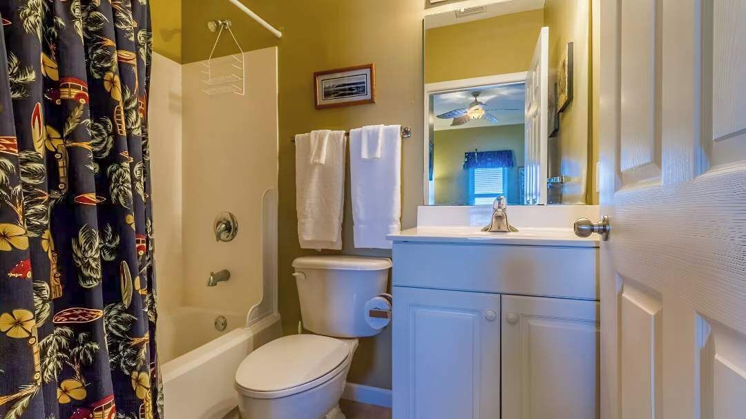 A bathroom with a toilet, sink, and shower.