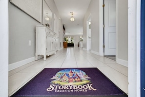 Un pasillo con un felpudo que muestra el logo de Storybook Vacation Homes.