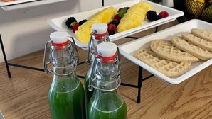 A kitchen counter with various food items and green bottles. - JEES B&B (Mexico City)