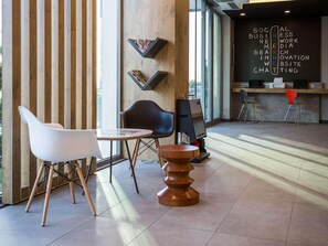 Un intérieur moderne avec un mur composé de lattes de bois, une table ronde avec une chaise blanche et une chaise noire.