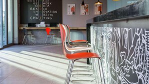 A modern interior with a reception desk, bar area, and seating. - Ibis Istanbul West (Istanbul)