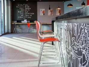 A modern interior with a reception desk, bar area, and seating. - Ibis Istanbul West (Istanbul)