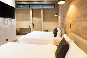 Deluxe-huone | Ylelliset vuodevaatteet, untuvapeitot, työpöytä