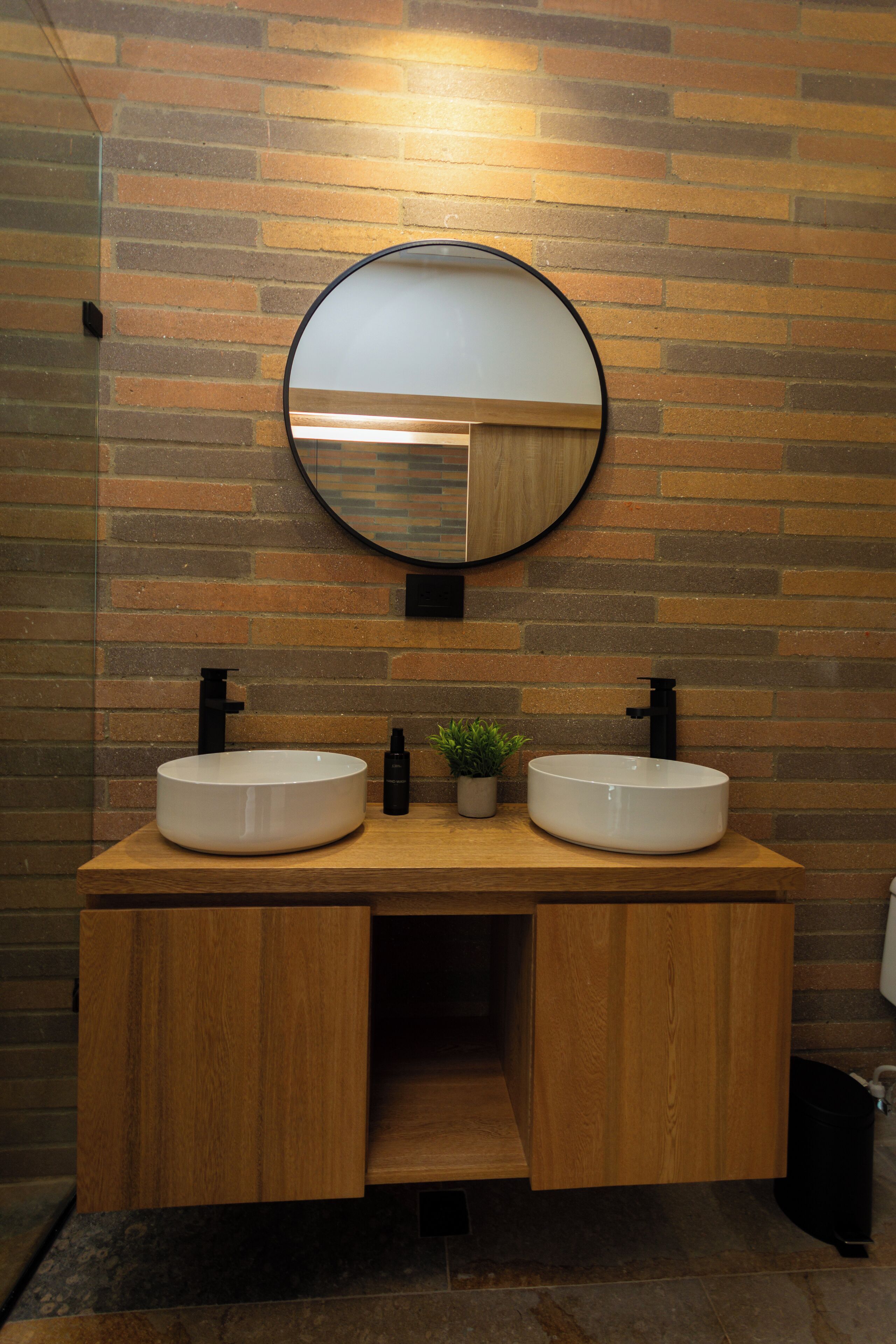 A bathroom with two sinks, a mirror, and a wooden vanity.