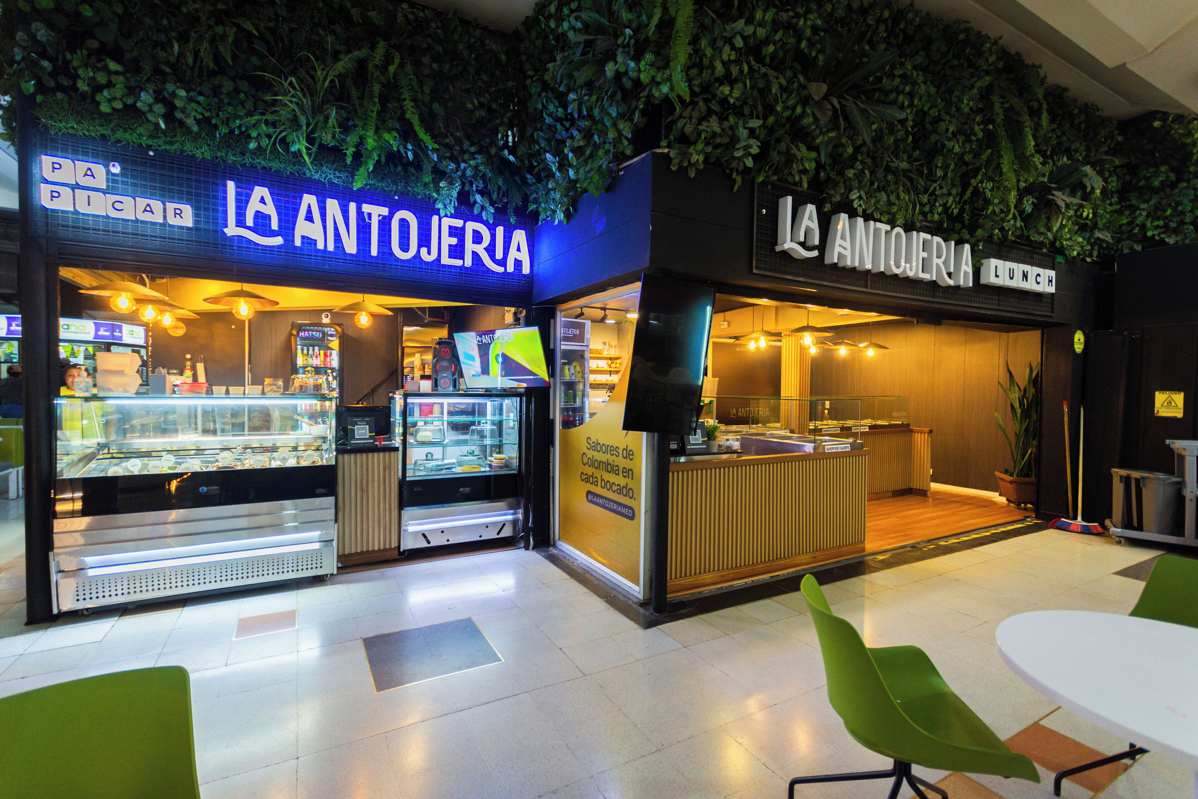 A restaurant named 'LA ANTOJERIA' with a glass display case and a counter area.