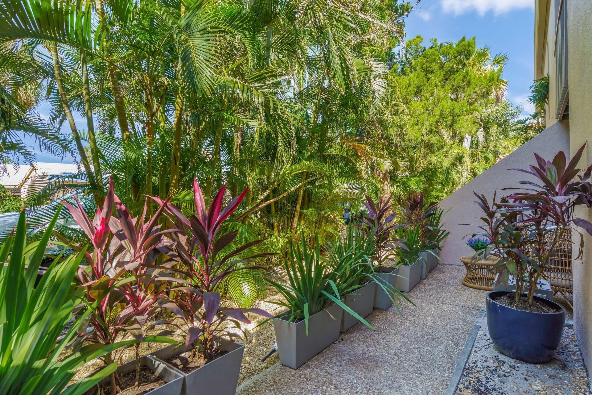 A balcony with potted plants and a view of the sea.
