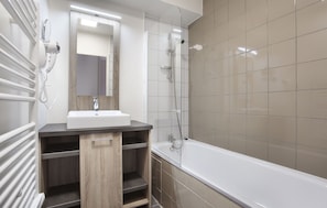 A modern bathroom with a white sink, mirror, and shower. - Residence Odalys Le Village de Praroustan (Uvernet-Fours)