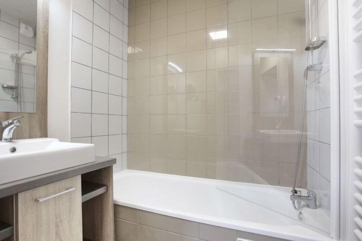 Baño con lavabo, espejo y ducha.