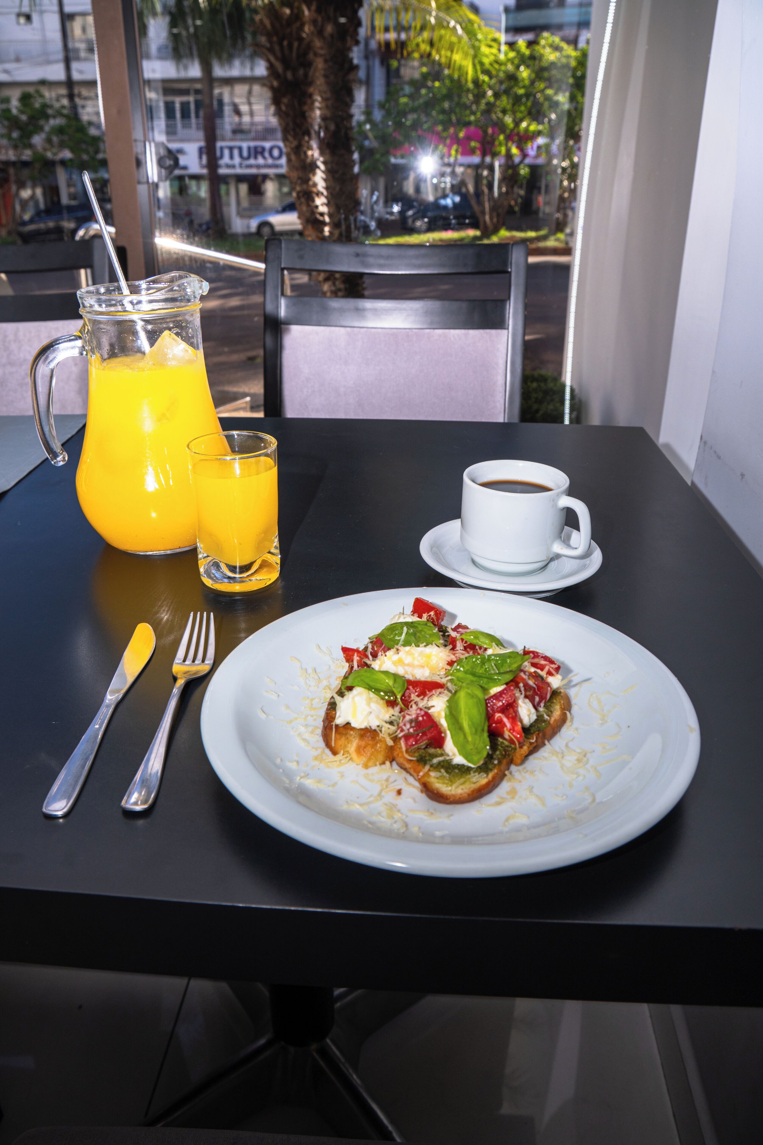 Ett bord med en måltid, ett glas apelsinjuice och en kopp kaffe.