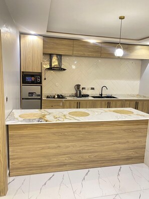 Standard Apartment, City View | Private kitchenette | Full-sized fridge, microwave, stovetop, cookware/dishes/utensils - Aurelia Apartments (Abuja)