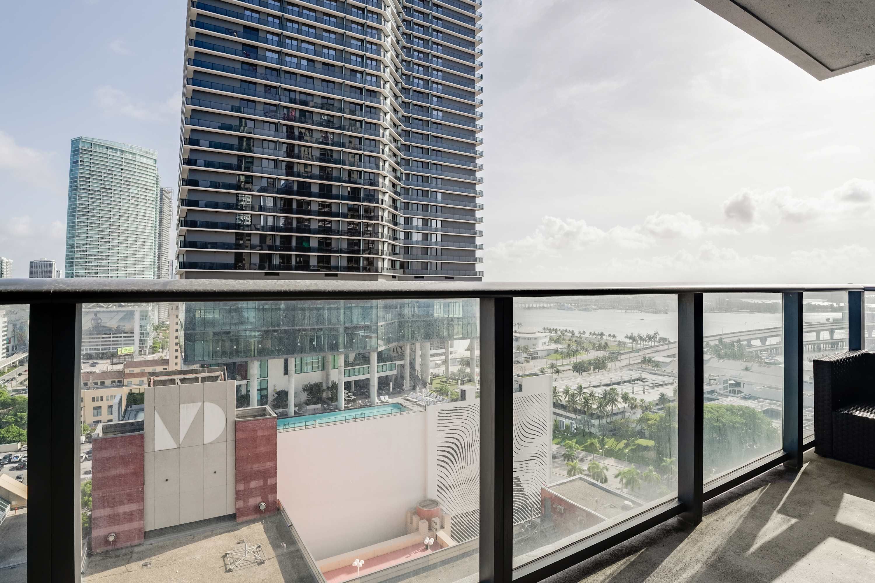 A high-rise building with a large glass window overlooking a cityscape.