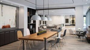 Un intérieur moderne comprenant un coin repas, des canapés et des luminaires suspendus.