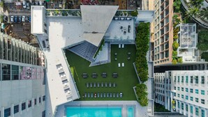 An aerial view of a modern building with a rooftop pool, lounge area, and surrounding greenery. - Downtown Miami Skyline Balcony Penthouse Suite Near Port Luxe Pad (Miami)