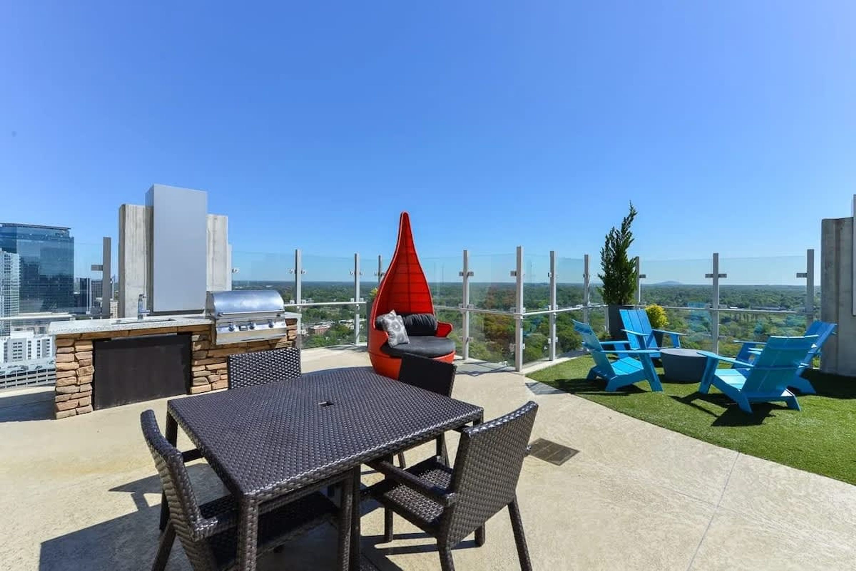 Una terraza en la azotea con una parrilla, zona de estar y vistas a la ciudad.