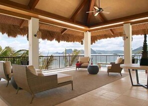 A covered outdoor seating area with chairs and a table, overlooking a scenic view. - El Nido Resorts Pangulasian Island (El Nido)