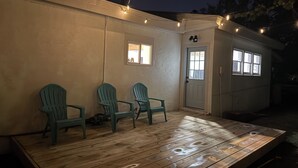Un ponteggiato in legno con tre sedie, una porta e finestre.