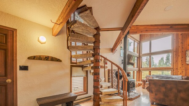 A wooden staircase with a spiral design leading to a lofted area. - Sans Souci 1 3 Bedroom Ski In, Ski Out Retreat (Whitefish)
