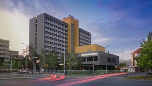 A hotel with a modern design, featuring a central building with a yellow accent and a smaller annex. - Hotel ILF (Prague)