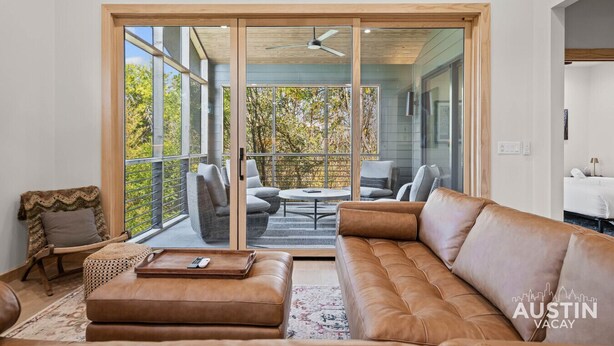 A spacious living room with a large sliding glass door leading to an outdoor patio area.