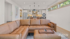 A spacious living room with a large leather sectional sofa and a wooden coffee table.