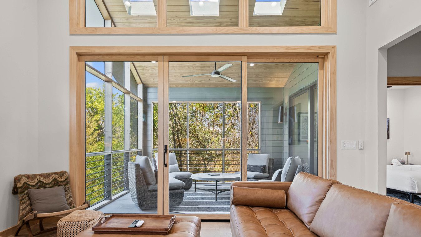 A spacious living room with a large sliding glass door leading to an outdoor patio area.