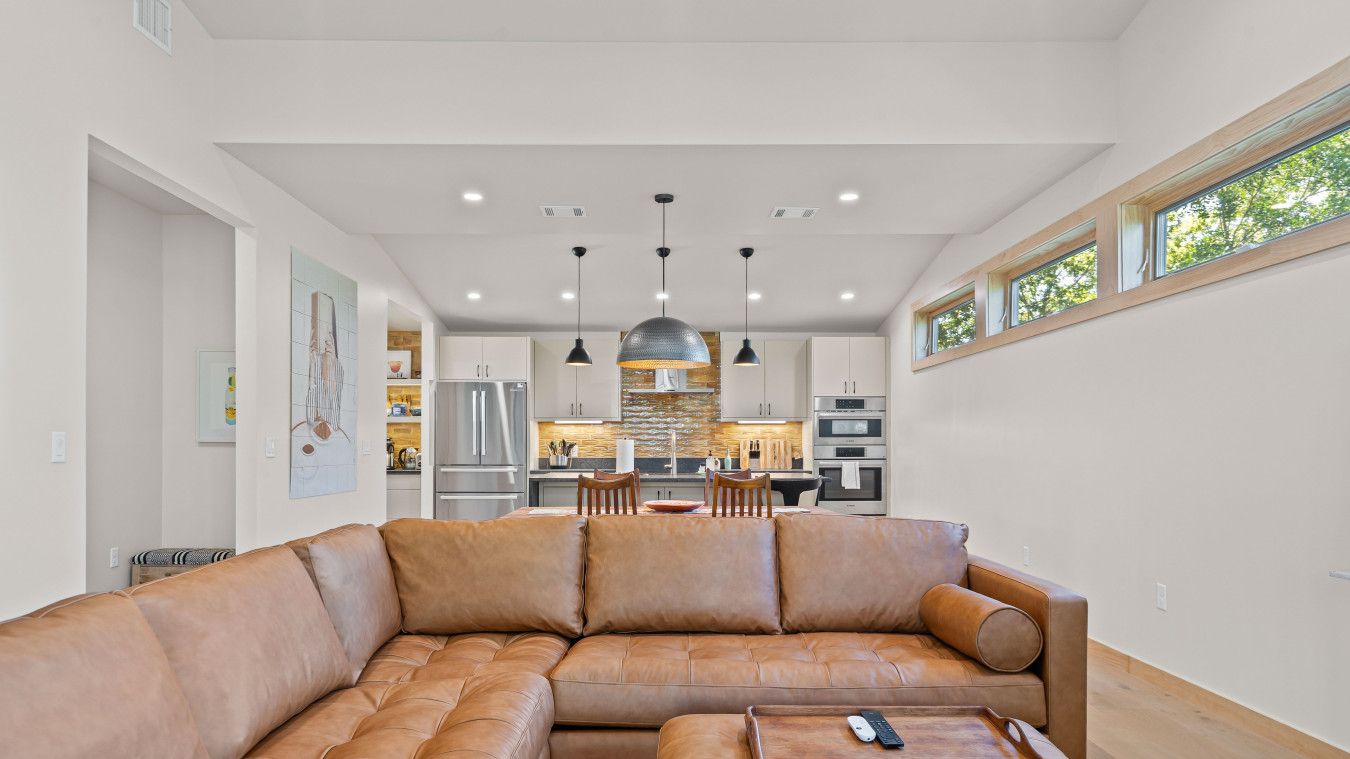 A spacious living room with a large leather sectional sofa and a wooden coffee table.