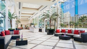 A spacious lobby with modern furnishings, large windows, and palm trees. - Westin Lagunamar Ocean Resort & Spa (Cancún)