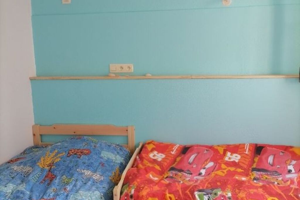 Une chambre à coucher avec deux lits, chacun recouvert d’une couvre-lit à motifs différents.
