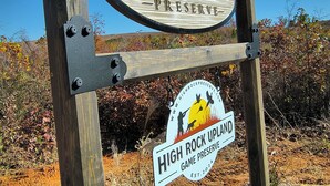 Un letrero de madera con el texto "High Rock Preserve" y "High Rock Upland", en un entorno natural.