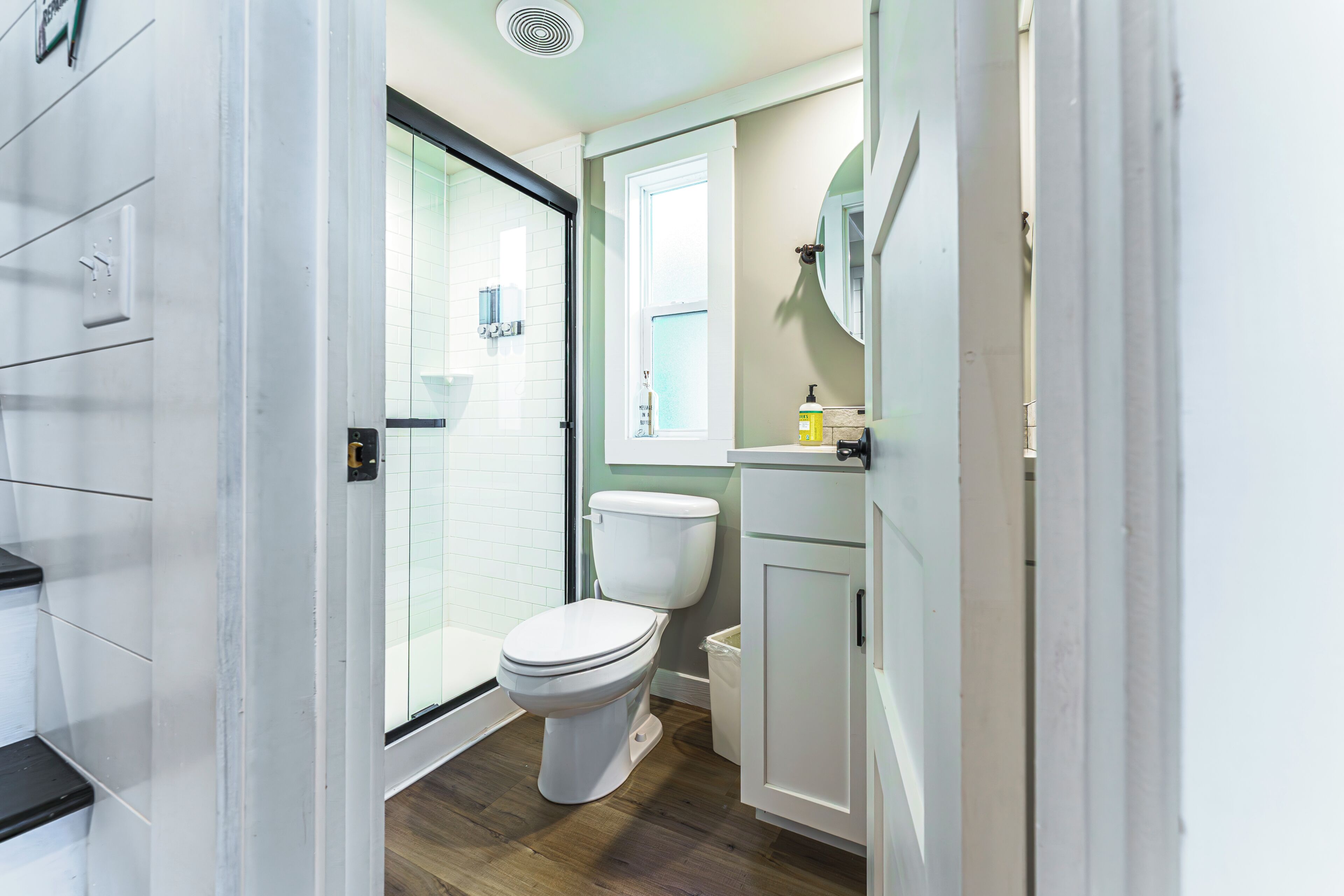 A bathroom with a toilet, a shower, and a sink.