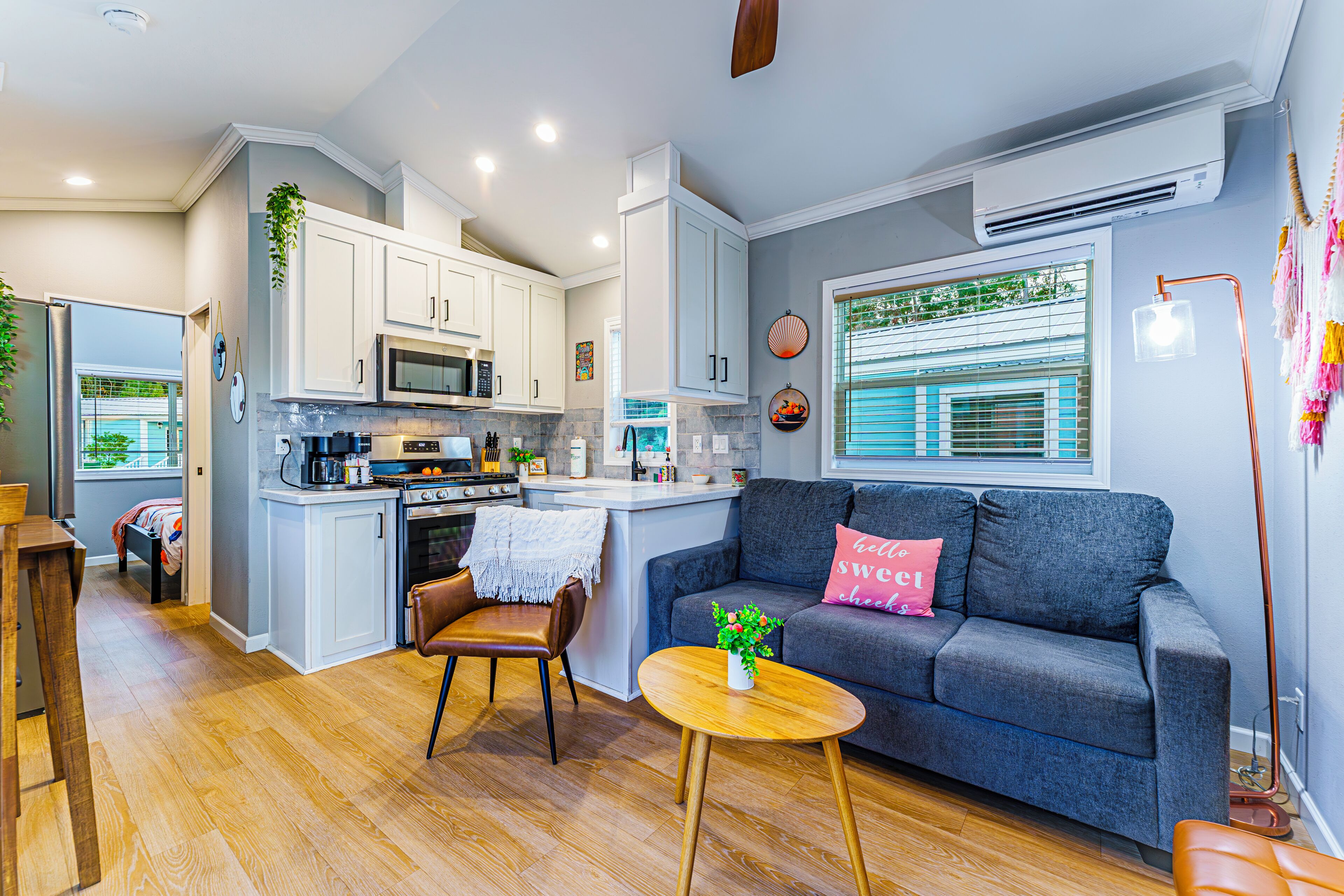 A modern kitchen with white cabinets, a central island, and a dining area with a wooden table and chairs.
