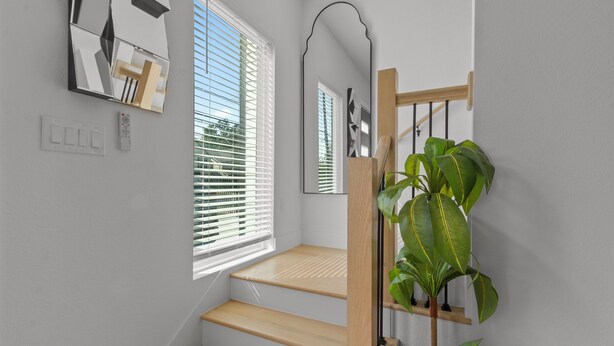A staircase with wooden steps and a plant on the right. - Elevated Luxury 3BR • Mins to NRG • Med Center • Downtown • GRB (Houston)