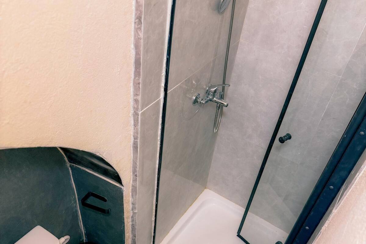 A bathroom with a toilet, a shower, and a sink.