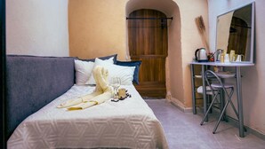 A bedroom with a bed, a desk, and a mirror. - roga bjeruslem (Jerusalem)