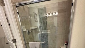 A glass-enclosed shower with a towel rack and a small shelf. - Charming pet friendly mountain views . Hottub included (Colorado Springs)