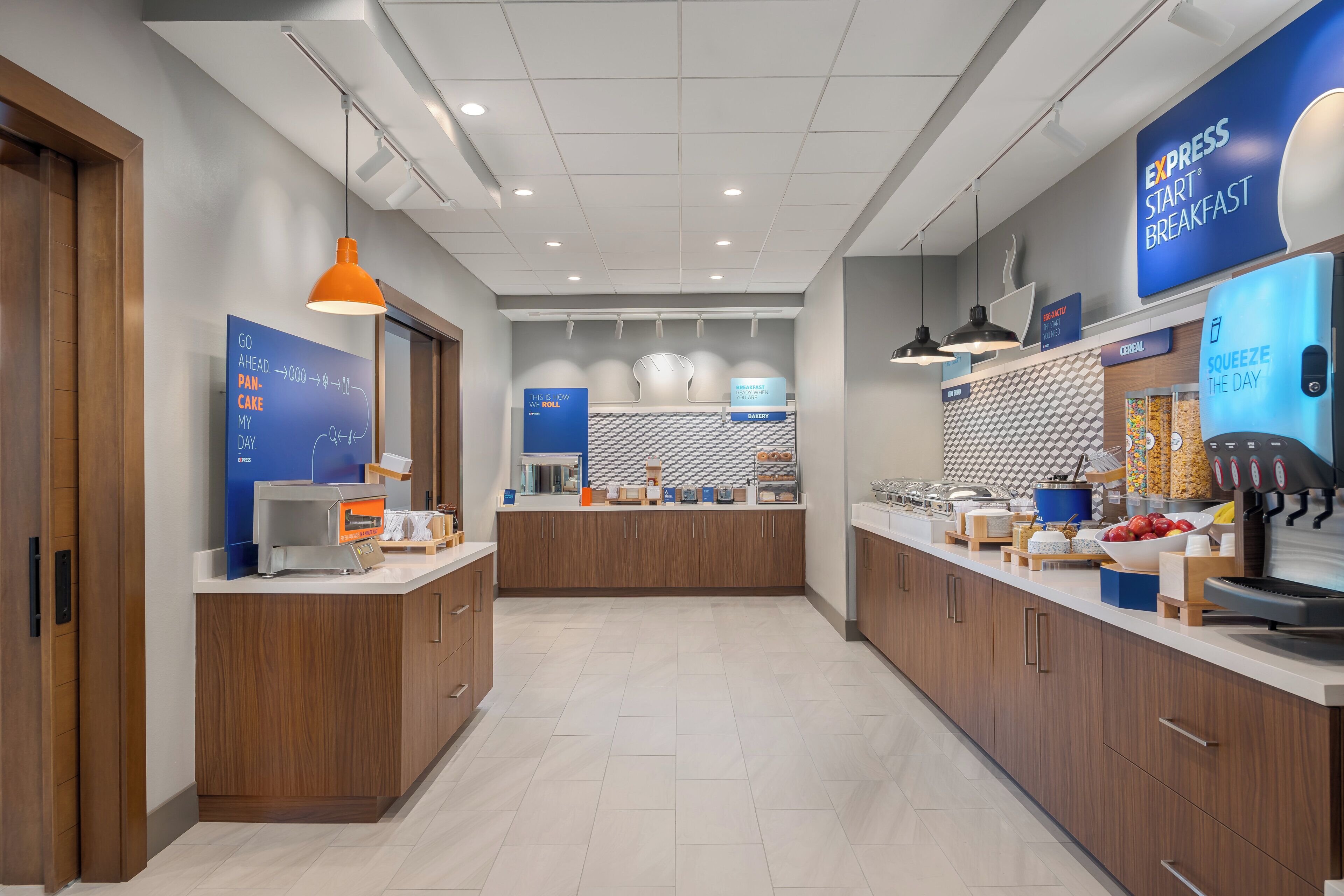 Una cocina moderna con barra de desayuno, armarios de madera y un letrero azul para Desayuno Express.