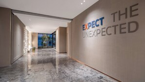 A modern hallway with a marble floor and a wall with the text 'EXPECT THE UNEXPECTED.' - Holiday Inn Express Beijing Tongzhou by IHG (Tongzhou)