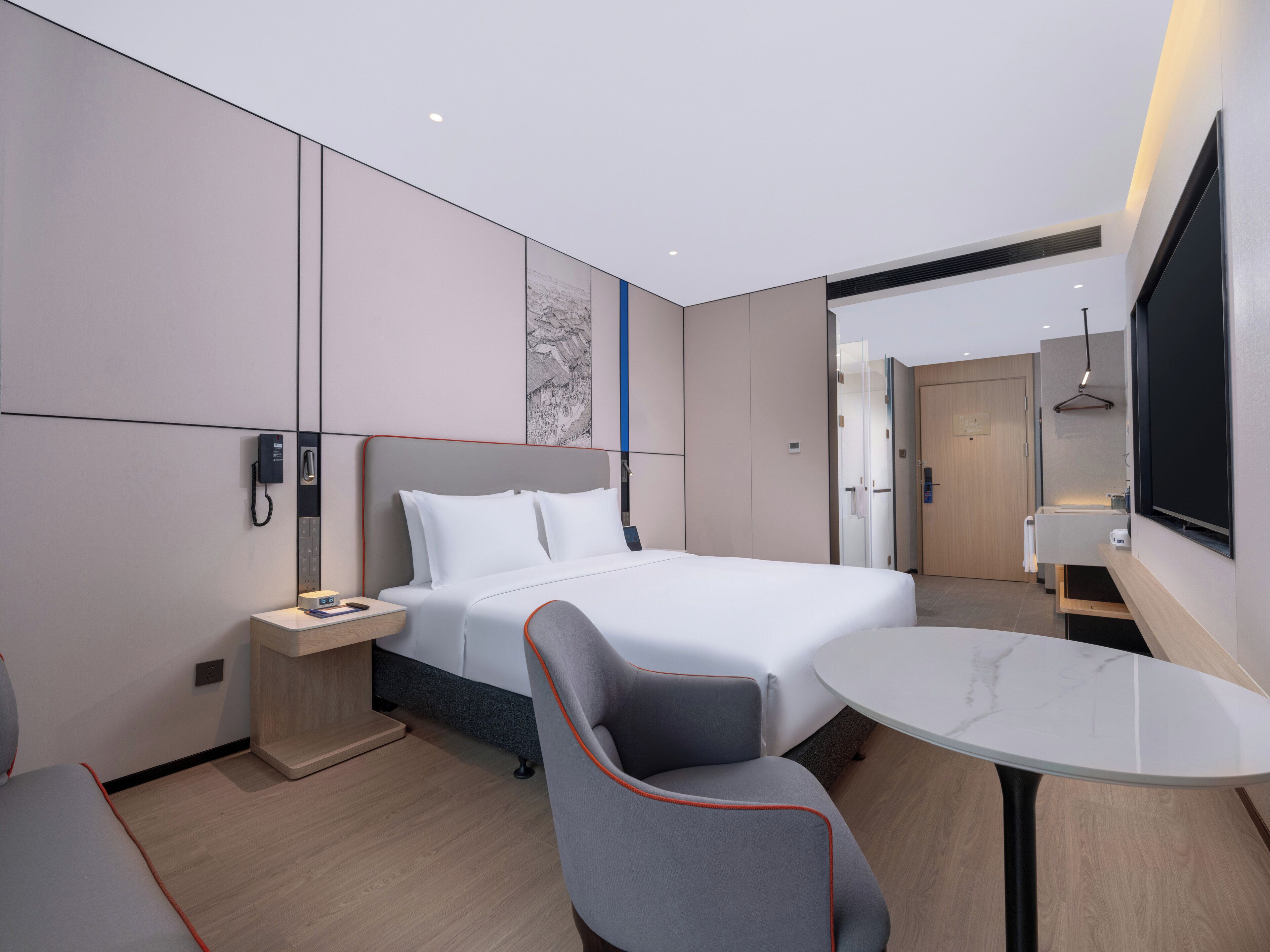 Una camera d'albergo moderna con un letto, un comodino, una sedia e un tavolino.