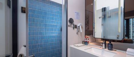 A modern bathroom with a large mirror, a sink, and a towel rack.