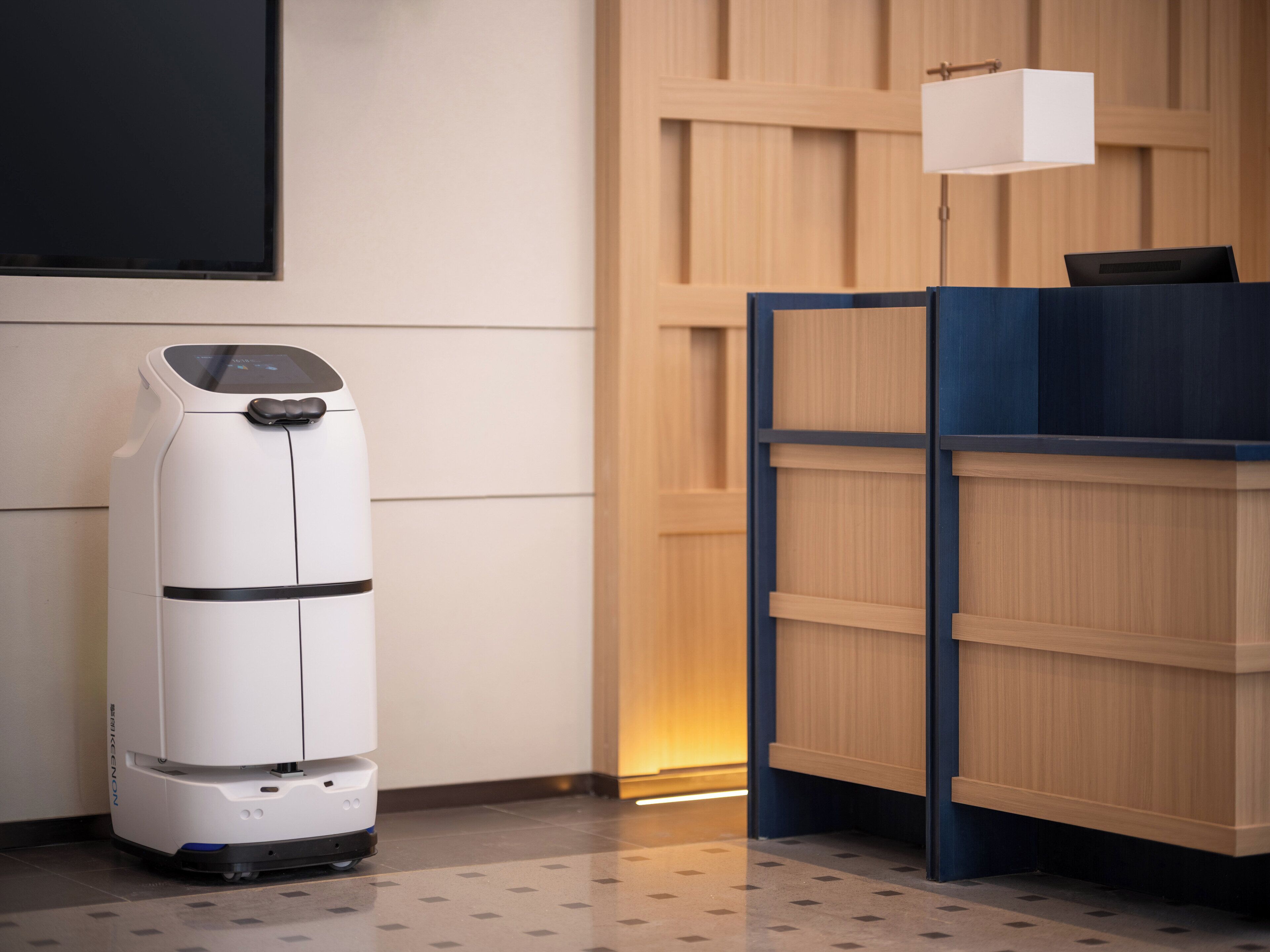 A room with a white air purifier, a wooden cabinet, and a wall-mounted light fixture.