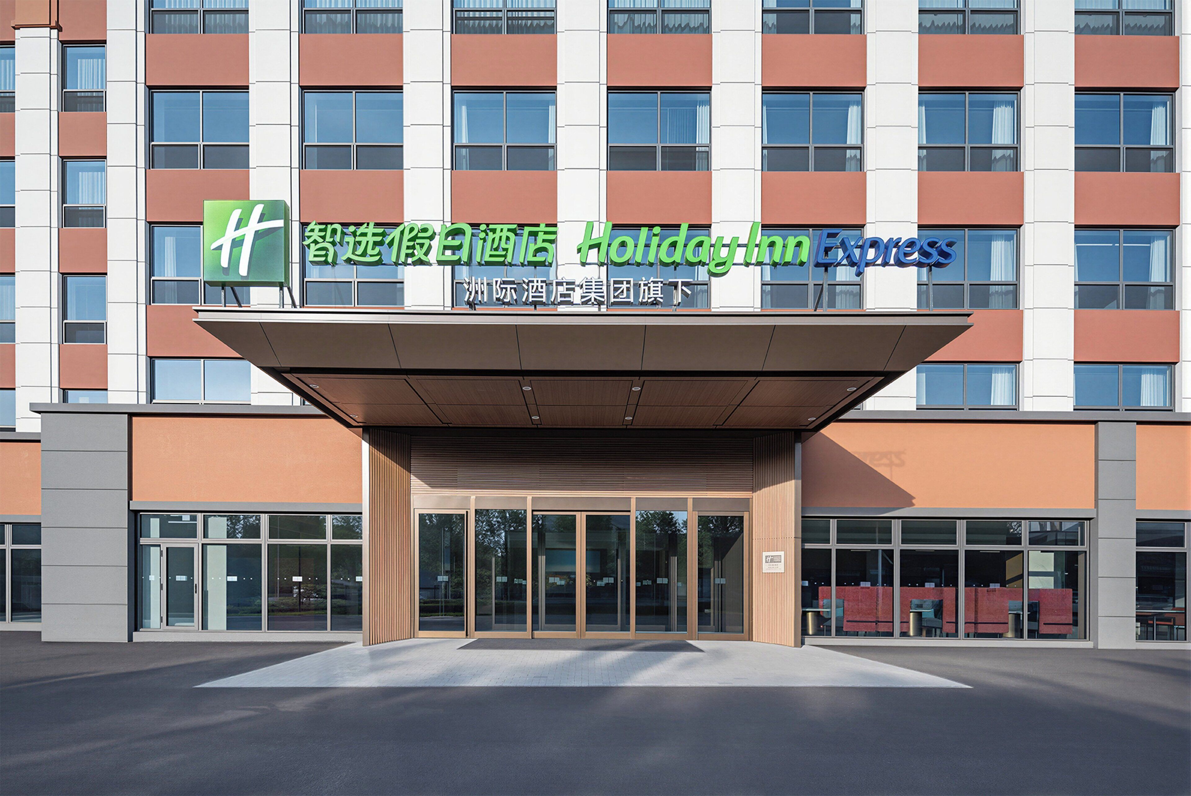 A Holiday Inn Express hotel with a modern facade, large windows, and a prominent entrance.