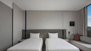 A hotel room with two beds, a sofa, a large window, and a wall-mounted phone. - Holiday Inn Express Changbaishan Beauty Pine by IHG (Yanbian)