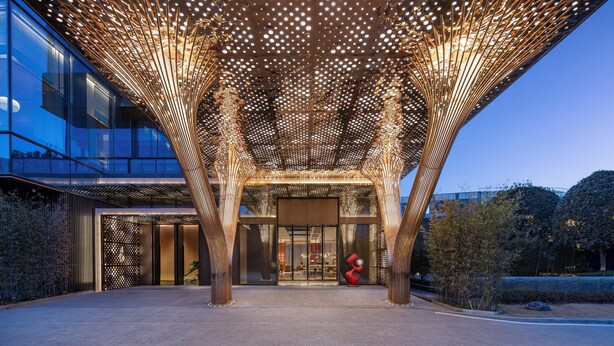 A modern building entrance with a unique ceiling design and a prominent red sculpture. - Hotel Indigo Xi An High Tech Zone by IHG (Xi'an)