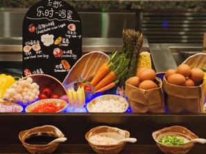 A food display with various ingredients and dishes, including vegetables, eggs, and a sign with dish names. - Hotel Indigo Xi An High Tech Zone by IHG (Xi'an)