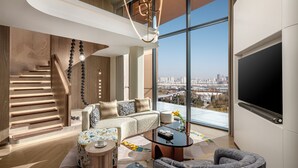 A modern living room with a staircase, a sofa, a coffee table, and a large window with a city view. - Hotel Indigo Xi An High Tech Zone by IHG (Xi'an)