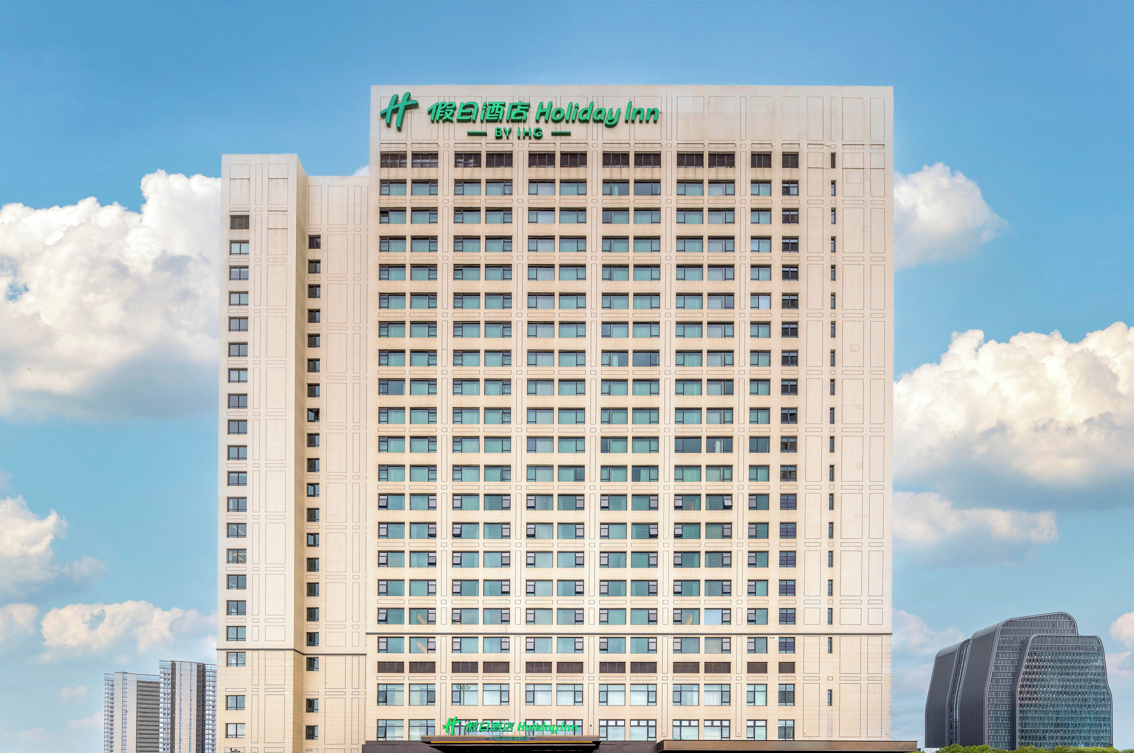 A high-rise hotel with a uniform facade, multiple windows, and a prominent signage at the top.