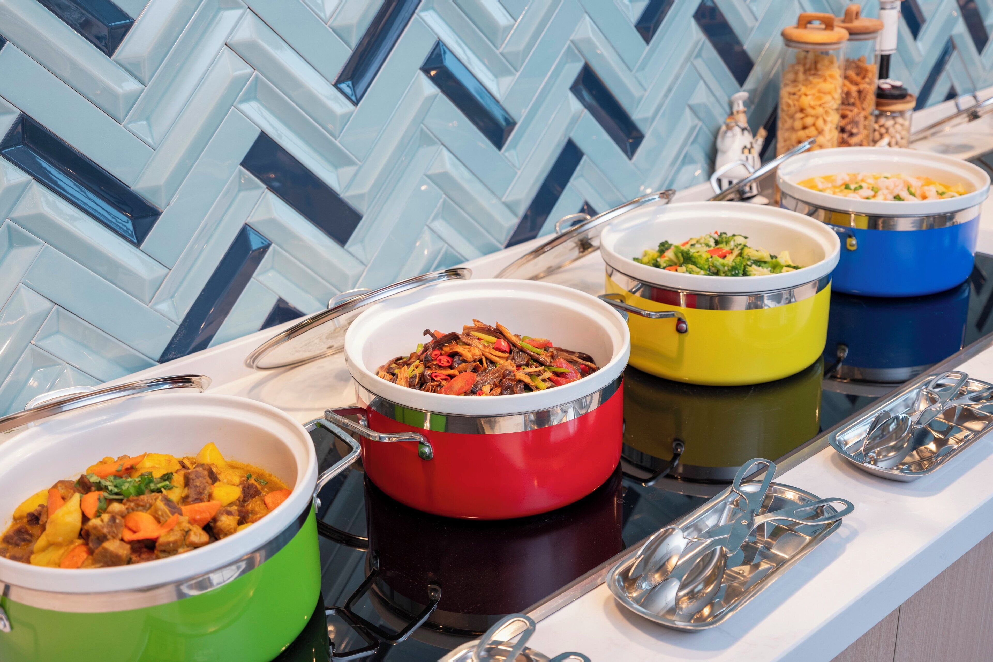 Una mesa de buffet con diversos platos en coloridos recipientes.