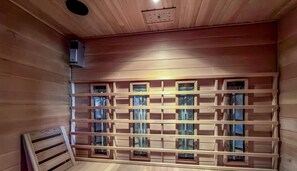 Ein Holzinnenraum mit einer Bank und einer Wand mit mehreren kleinen Fenstern.