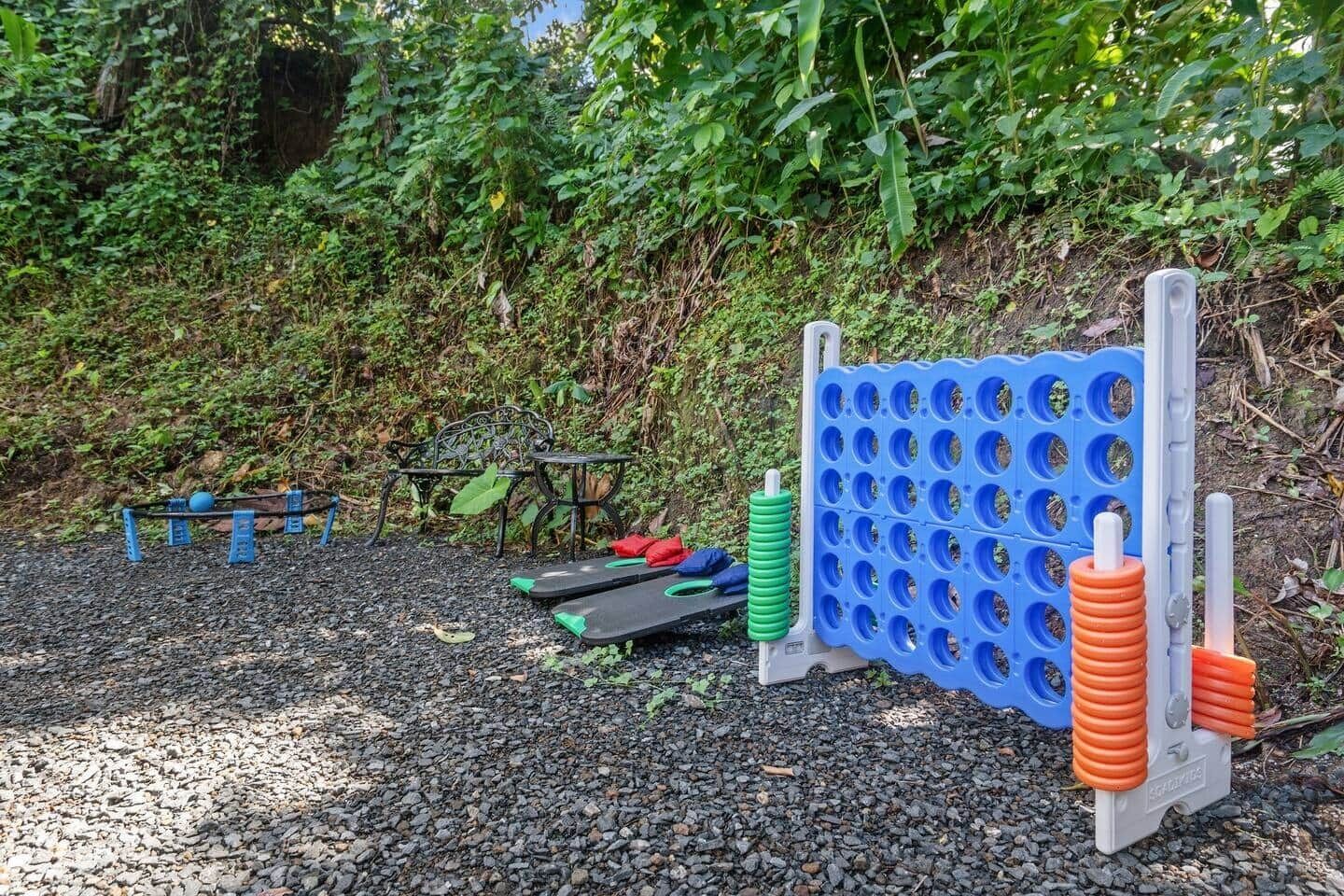 Uma área de exercícios ao ar livre, com uma parede de exercícios azul e laranja, um banco de metal e uma mesa.